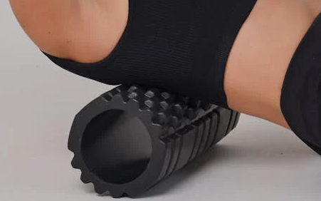Close up of person using a textured roller for back massage